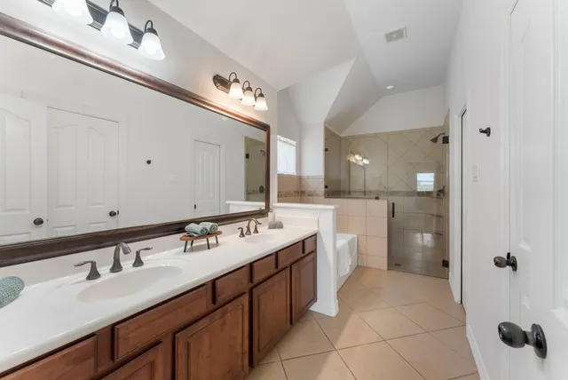 a bathroom with a sink double vanity granite and a mirror