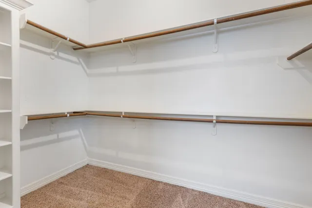 a view of walk in closet with empty racks