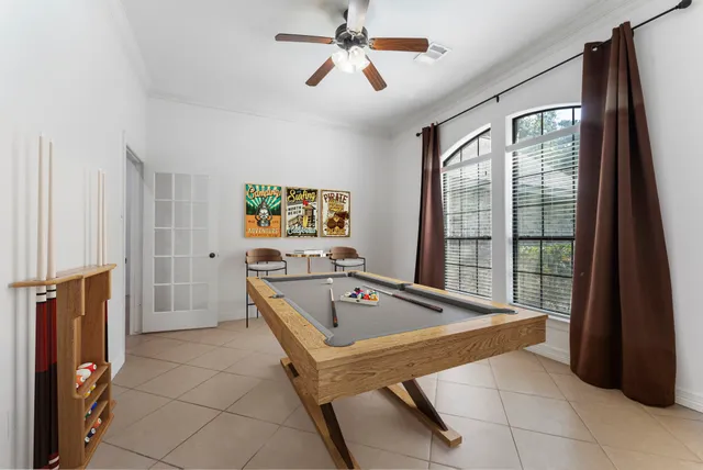 a living room with furniture a flat screen tv and a floor to ceiling window