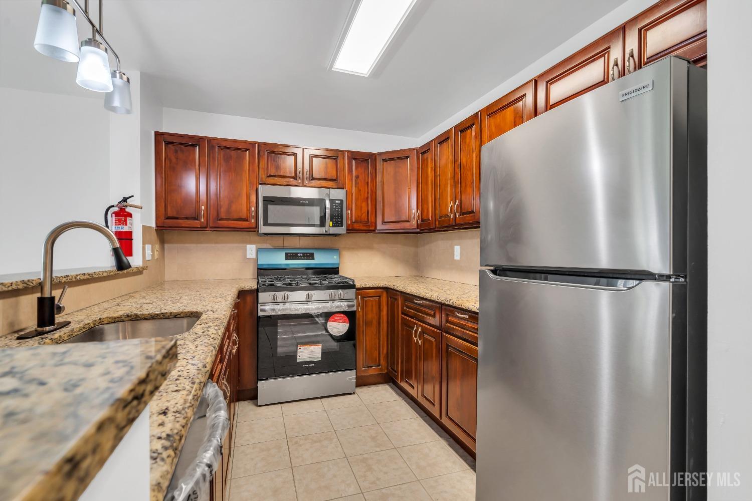 812 Edpas Road New Brunswick, NJ 08901 - Photo 4 of 31 a kitchen with stainless steel appliances granite countertop a refrigerator sink and stove