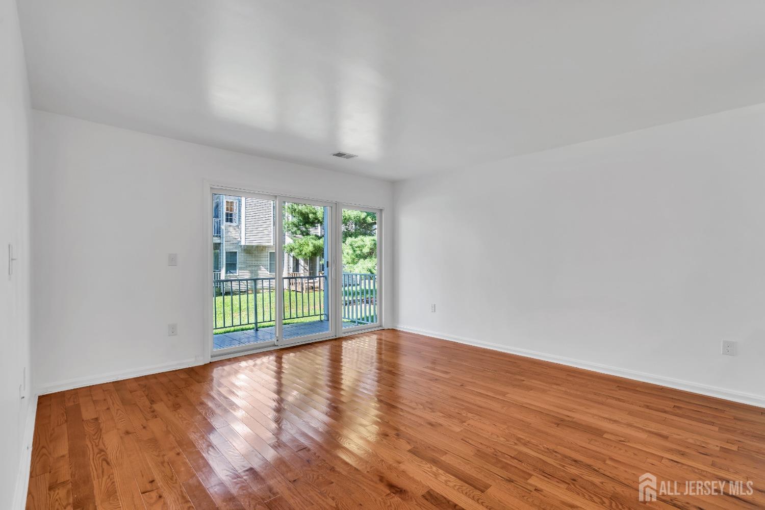 812 Edpas Road New Brunswick, NJ 08901 - Photo 10 of 31 a view of an empty room with wooden floor and a window