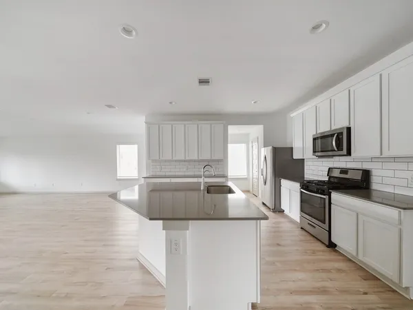 a kitchen with stainless steel appliances kitchen island wooden cabinets and granite counter tops