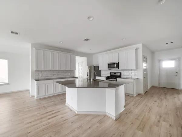 a kitchen with sink and wooden floor
