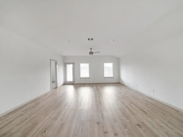 a view of empty room with wooden floor
