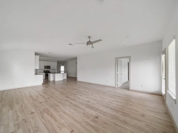 a view of a livingroom with wooden floor and a ceiling fan