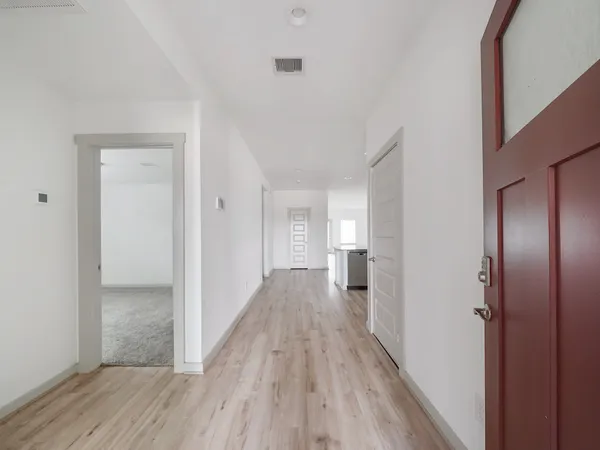 a view of a hallway with wooden floor