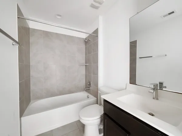 a bathroom with a sink a toilet a mirror and a glass door shower