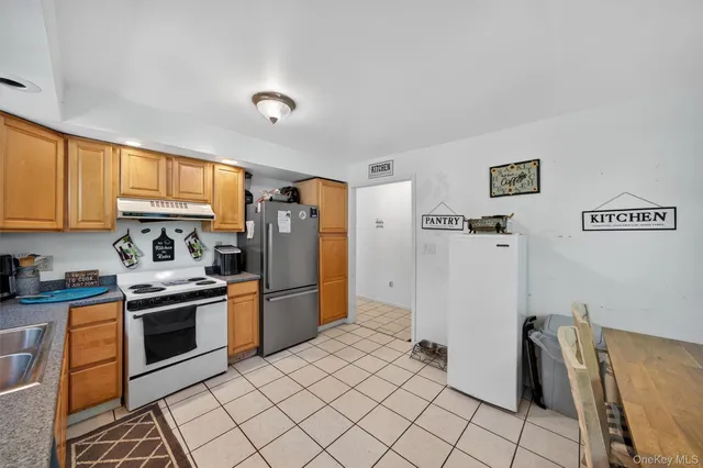 a kitchen with stainless steel appliances granite countertop a refrigerator and a stove top oven