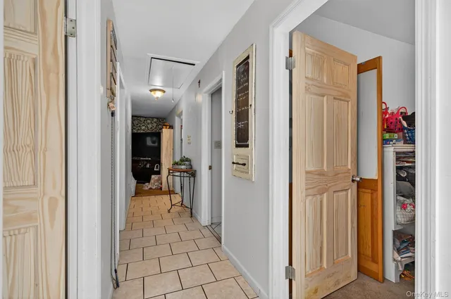 a view of a hallway with closet and a living room
