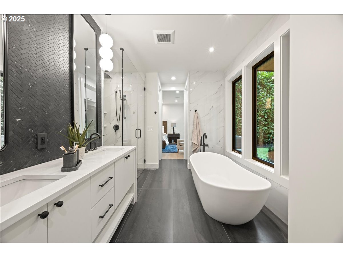 1572 Chandler Road Lake Oswego, OR 97034 - Photo 36 of 47 a spacious bathroom with a double vanity sink a large mirror a bathtub and shower
