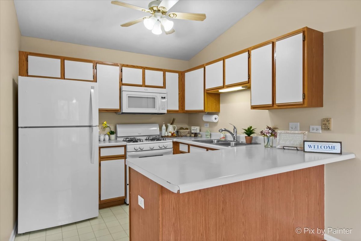 1023 Berkshire Court, Unit C Elgin, IL 60120 - Photo 12 of 54 a kitchen with a refrigerator a stove a sink and a center island