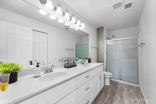 a bathroom with a double vanity sink mirror and shower
