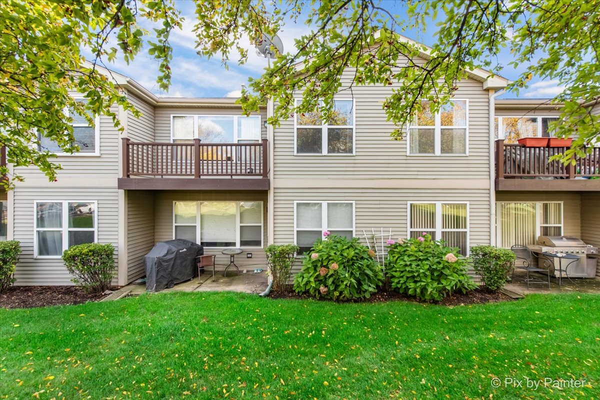1023 Berkshire Court, Unit C Elgin, IL 60120 - Photo 32 of 54 a front view of a house with porch and garden