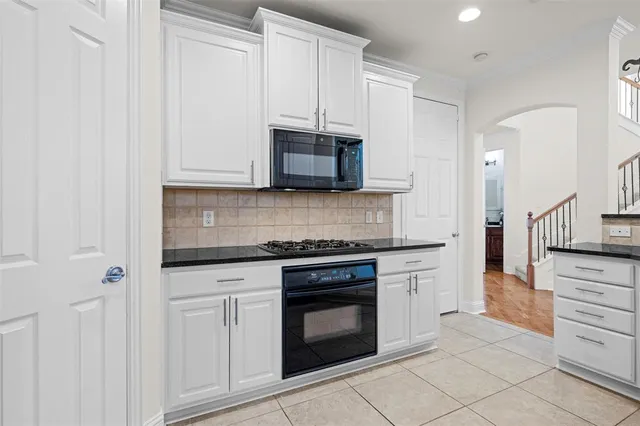 a kitchen with stainless steel appliances granite countertop a refrigerator a sink dishwasher a stove and a dining table with wooden floor