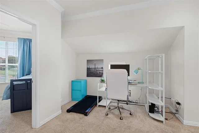 a view of a workspace with furniture and a window