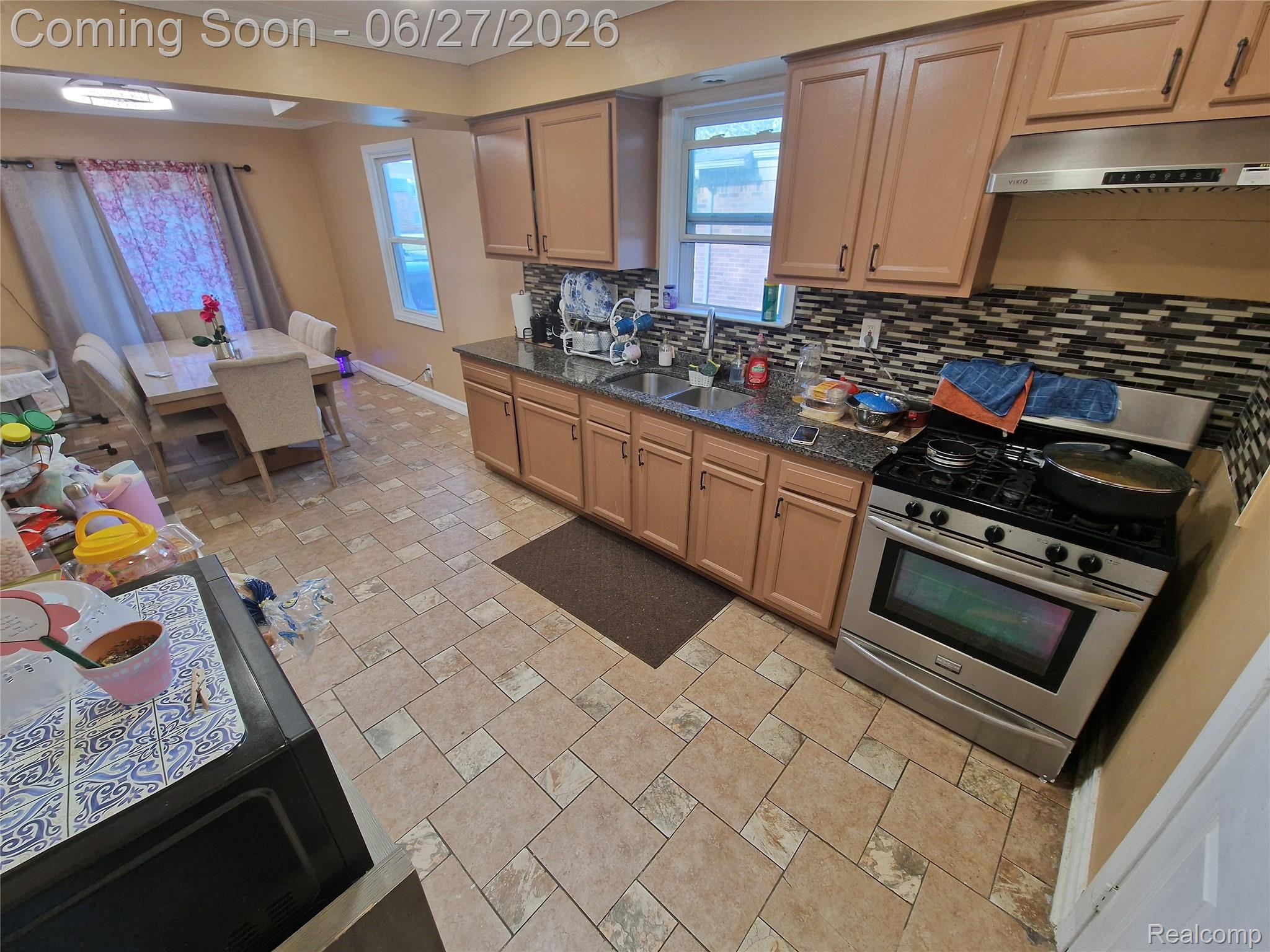 4320 Frazho Road Warren, MI 48091 - Photo 21 of 27 Kitchen featuring wood-finish cabinetry, granite countertops, and a mosaic tile backsplash