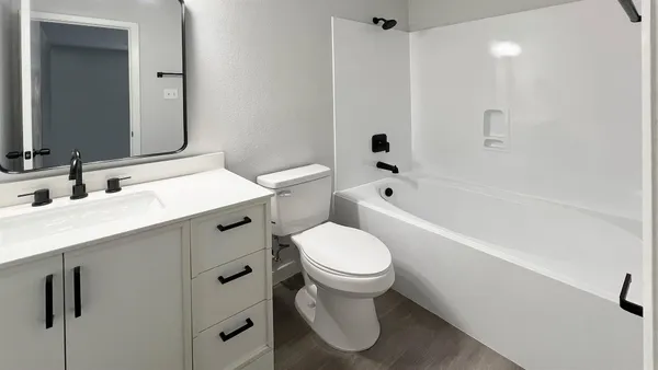 a view of a room with wooden floor and a ceiling fan