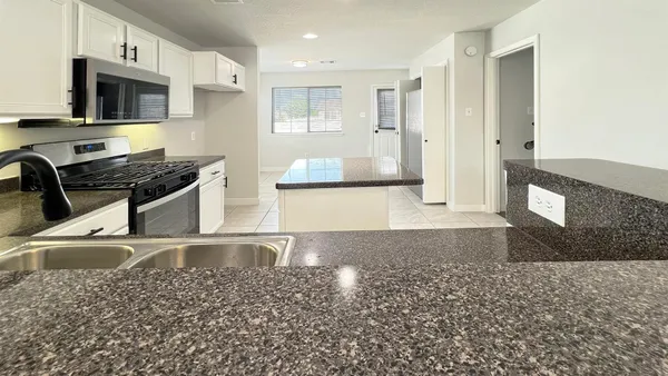 a living room with kitchen island furniture and a flat screen tv