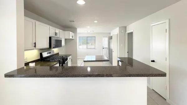 a kitchen with stainless steel appliances granite countertop a refrigerator and a sink
