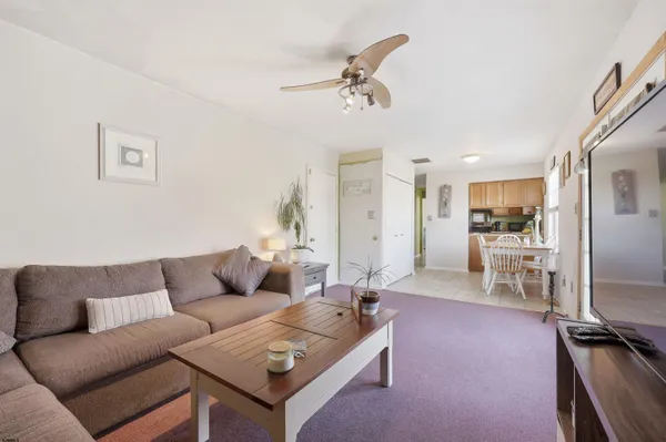 a living room with furniture and kitchen view