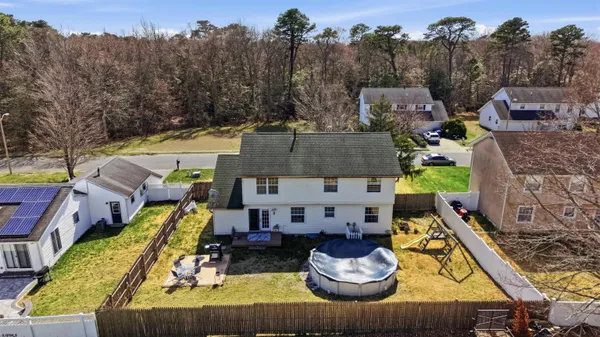 an aerial view of a house with swimming pool and a garden