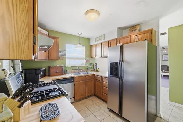 a kitchen with a refrigerator a stove a sink and a window