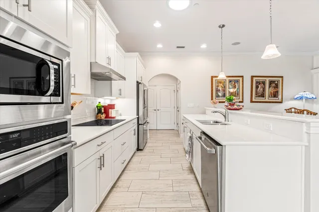 a large kitchen with stainless steel appliances kitchen island granite countertop a sink and cabinets