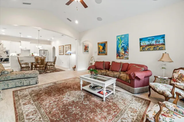 a living room with furniture a chandelier and a table