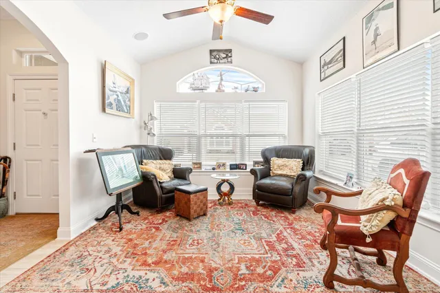a living room with furniture flowerpot and a chandelier