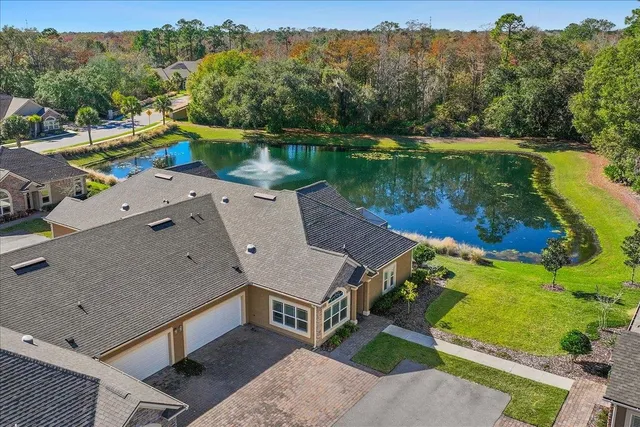 an aerial view of a house with a garden and lake view