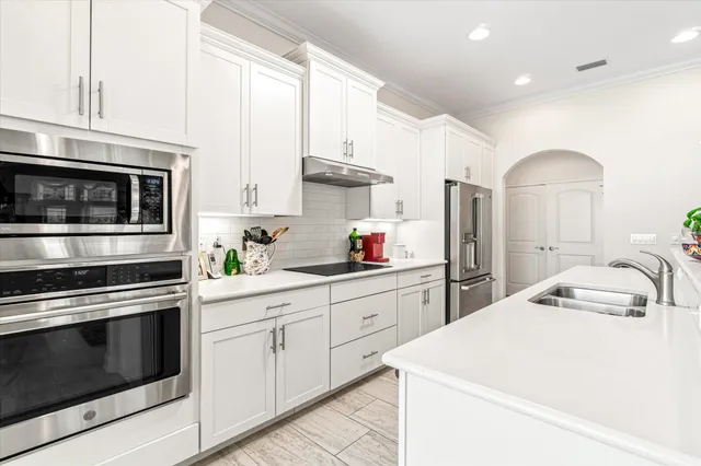 a kitchen with stainless steel appliances a sink a stove a microwave and cabinets