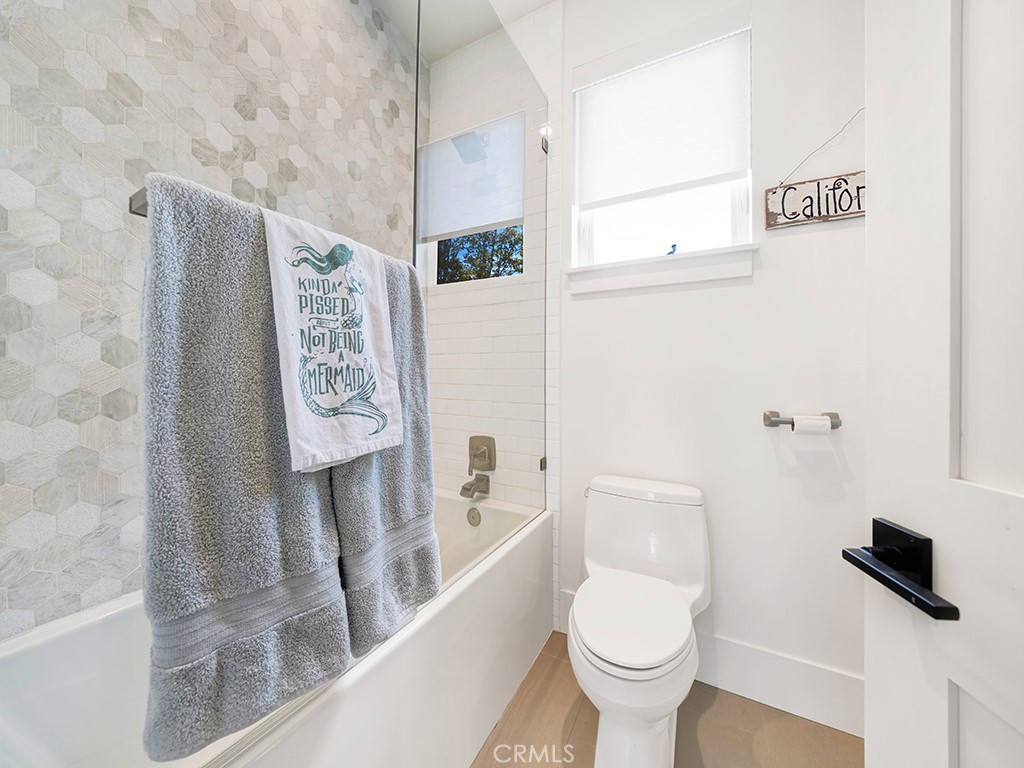 169 22nd Street Costa Mesa, CA 92627 - Photo 12 of 22 a white toilet sitting next to a bathroom sink and a mirror
