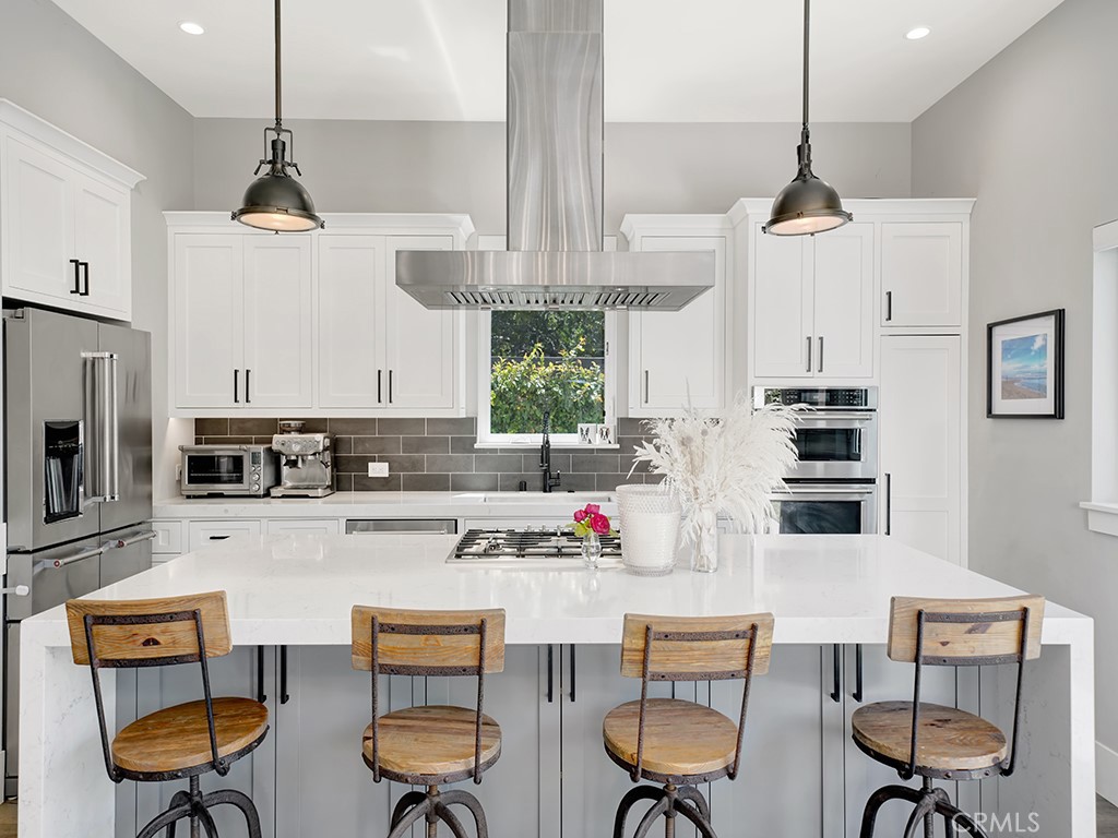169 22nd Street Costa Mesa, CA 92627 - Photo 3 of 22 a kitchen with stainless steel appliances kitchen island granite countertop a cabinets and chairs