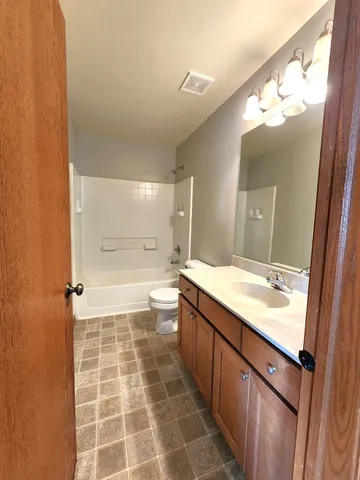 a bathroom with a large mirror vanity and a shower