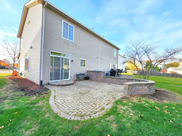 a view of a house with backyard and a tree