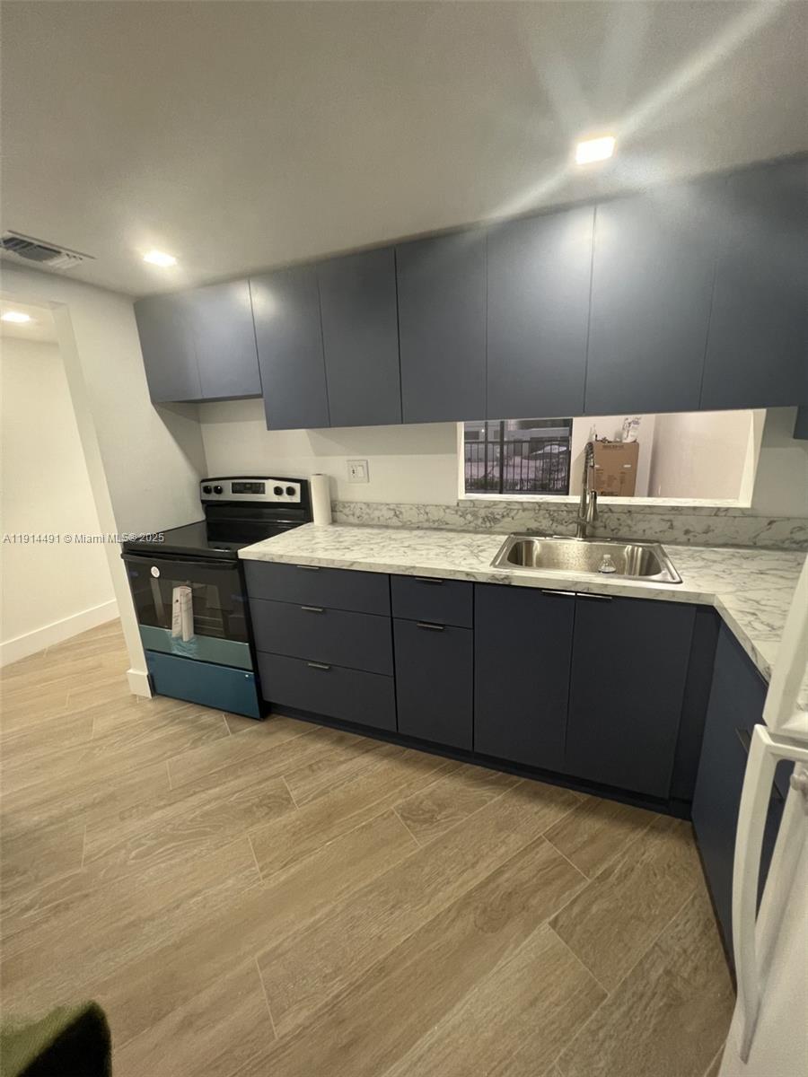 8015 Southwest 107th Avenue, Unit 213 Miami, FL 33173 - Photo 1 of 4 a kitchen with stainless steel appliances a sink a stove a refrigerator counter top space and cabinets