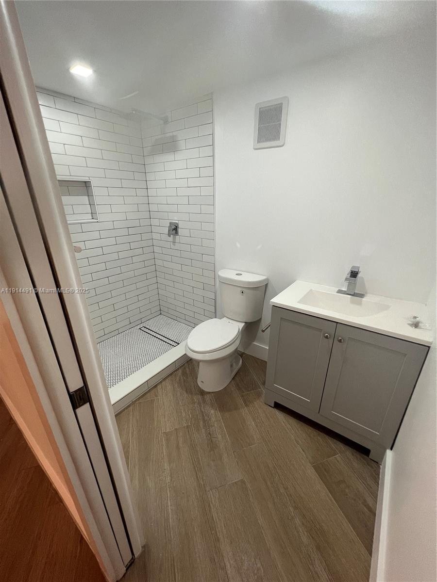 8015 Southwest 107th Avenue, Unit 213 Miami, FL 33173 - Photo 3 of 4 a bathroom with a sink a toilet a mirror and shower