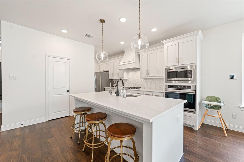 5244 Ranchero Trail Fort Worth, TX 76126 - Photo 7 of 33 Kitchen with white cabinets, appliances with stainless steel finishes, a breakfast bar, tasteful backsplash, and recessed lighting