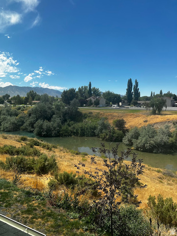 562 Hal Street, Unit 152 Tooele, UT 84074 - Photo 35 of 44 Expansive property featuring a tranquil body of water, natural landscaping, distant mountain ranges, and residential structures in the background
