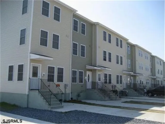 a front view of a building with lot of cars