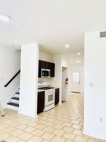 a view of a kitchen with wooden floor and electronic appliances