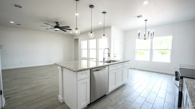 a kitchen with stainless steel appliances granite countertop a stove a sink and a refrigerator