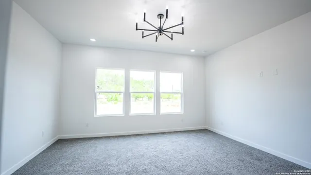 an empty room with windows and a ceiling fan
