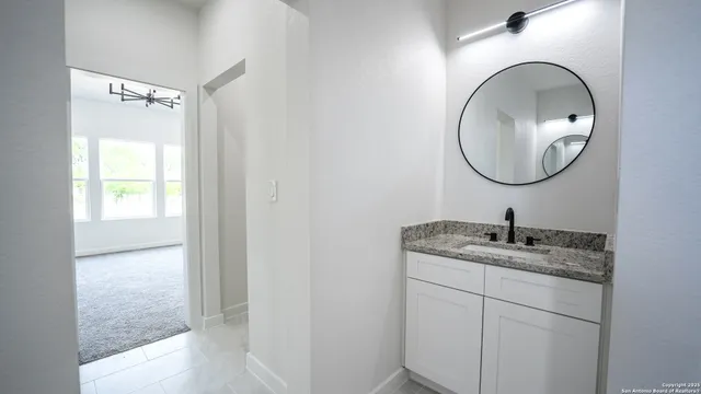 a bathroom with a granite countertop sink and a mirror