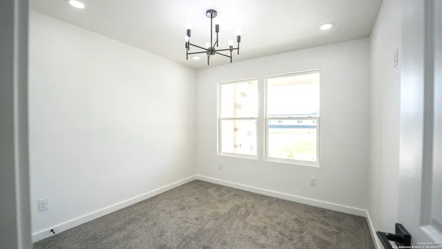 an empty room with a window and a ceiling fan