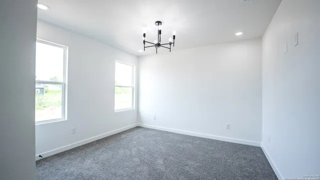 an empty room with windows and ceiling fan