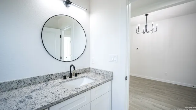 a bathroom with a granite countertop sink and a mirror