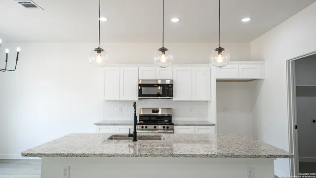 a kitchen with kitchen island a counter space a sink and a stove