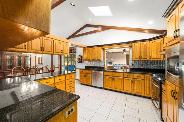 a kitchen with stainless steel appliances granite countertop a sink and cabinets