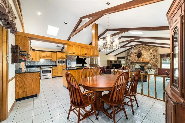 a dining room with stainless steel appliances kitchen island granite countertop a table and chairs